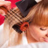 Hairdresser drying hair of a blonde woman / close-up